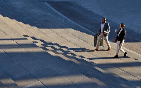 Two business professionals walking outdoors.