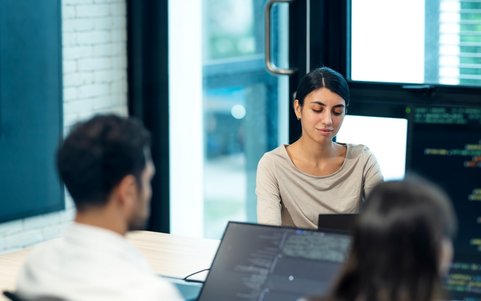 Employees working at a computer in an office.